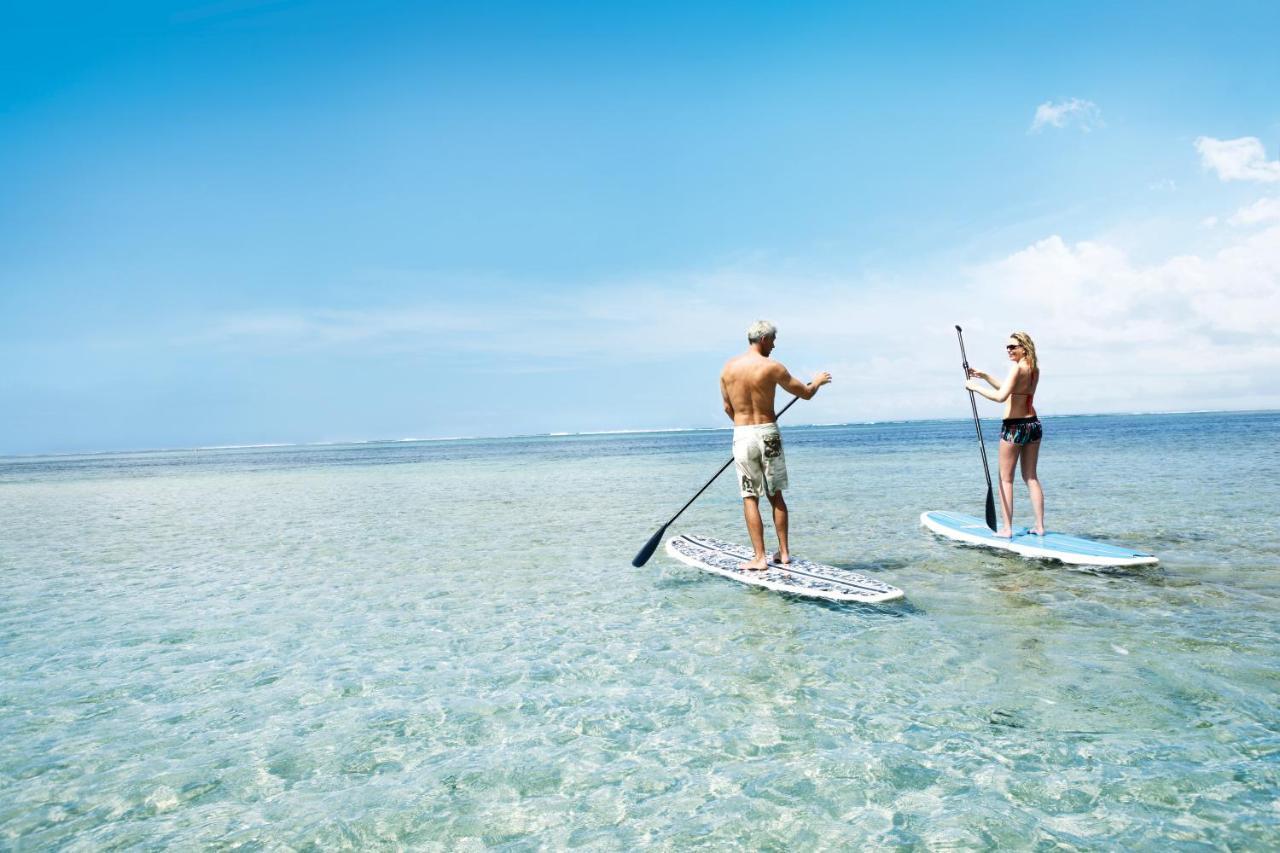 Heritage Le Telfair Golf & Wellness Resort Bel Ombre Bagian luar foto Stand-up paddle boarders on a lagoon