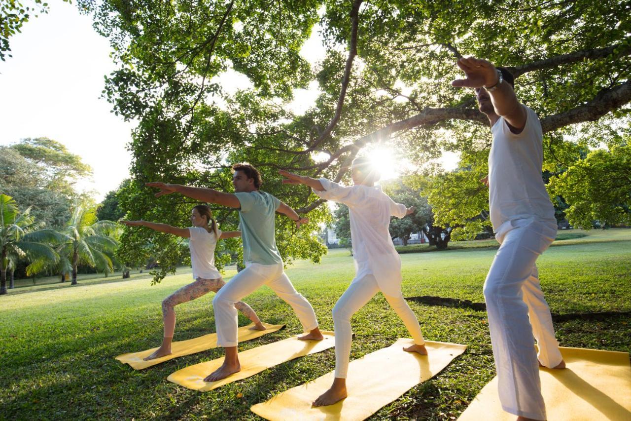 Heritage Le Telfair Golf & Wellness Resort Bel Ombre Bagian luar foto A group of people practicing yoga